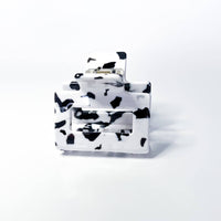Thumbnail for This is a miniature claw clip with a dalmatian print design, featuring irregular black spots on a white background. It has a classic spring-loaded hinge mechanism. The clip's compact size suggests it's ideal for securing smaller sections of hair, half-up styles, or for finer hair types.