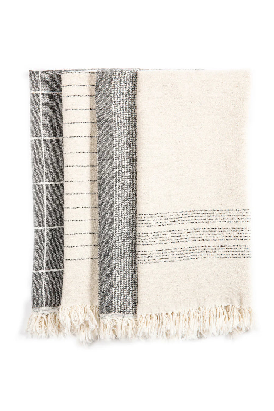 Four folded kitchen towels are neatly arranged against a bright white backdrop. The towel on the far left features a dark grey grid pattern with thin white lines. Adjacent to it, the next towel displays thin dark grey vertical stripes on an off-white base. The third towel showcases a textured pattern of small off-white rectangles arranged in vertical bands against a dark grey background. On the right, the final towel is predominantly off-white with thin horizontal dark grey stripes near its bottom edge. 