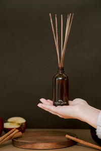 Thumbnail for A hand holds an amber glass bottle of a 