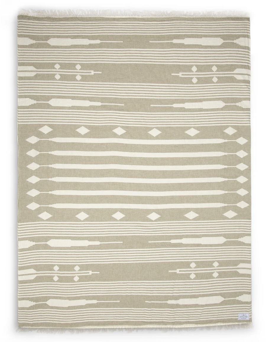 A khaki and white patterned throw blanket laid out flat.