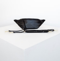 Thumbnail for A black, woven-textured fanny pack sits on a white surface with two detachable straps lying in front of it.