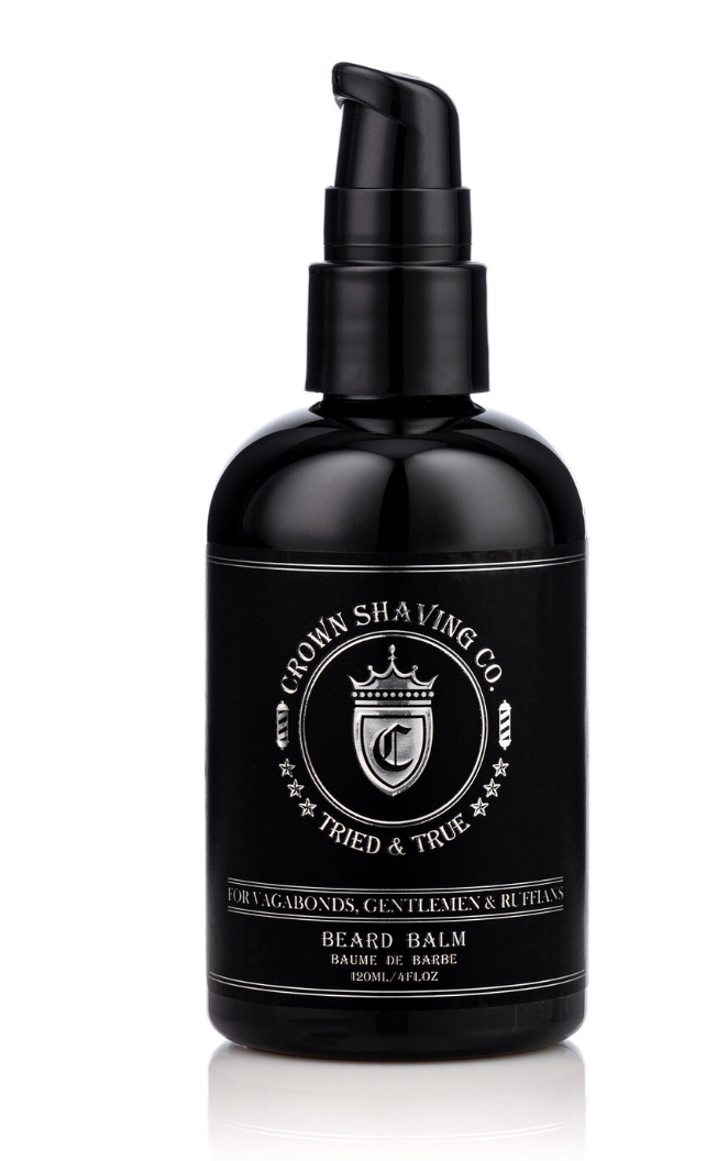 This image shows a black pump bottle of Crown Shaving Co. Beard Balm. The label features the brand's logo and the product name "BEARD BALM BAUME DE BARBE." The bottle is isolated against a white background.