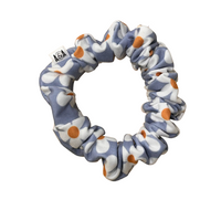 Thumbnail for Light blue scrunchie with a repeating pattern of white daisy flowers with bright orange centers.