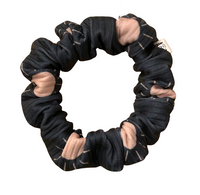 Thumbnail for scrunchie in a charcoal ribbed fabric with a pattern of light pink suns with thin sun rays. 