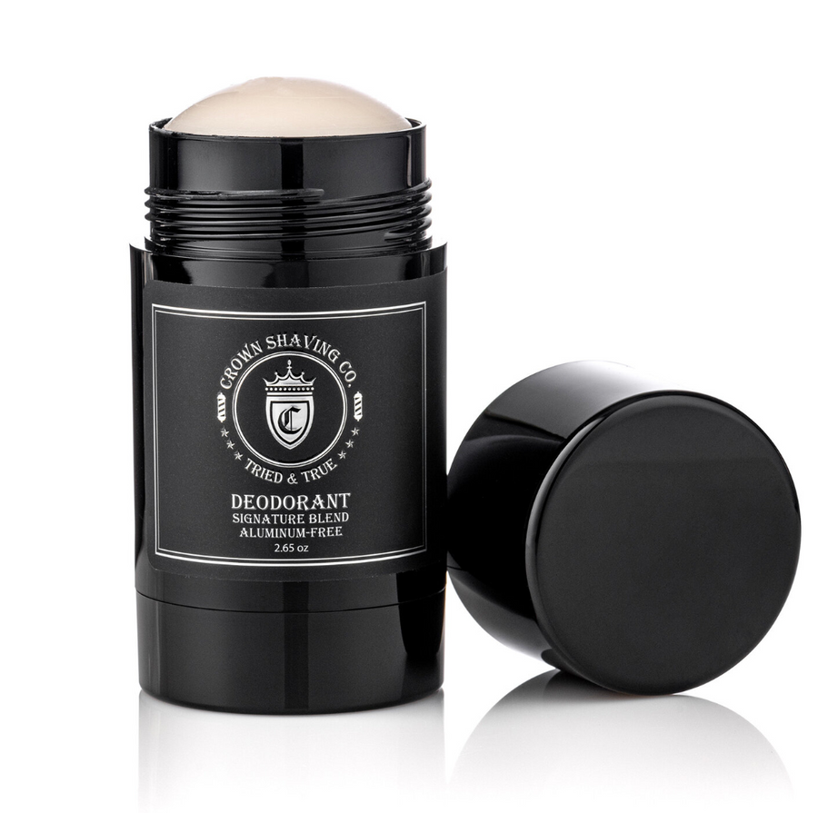 This image features a black container of Crown Shaving Co. Aluminum-Free Deodorant with its cap off. The label includes the Crown Shaving Co. logo and the text "DEODORANT SIGNATURE BLEND ALUMINUM-FREE." The product is set against a white background.