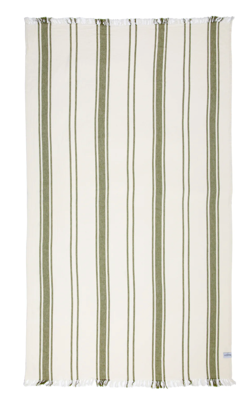 
A rectangular beach towel with a white background and evenly spaced vertical stripes in two shades of olive green, alternating between a thinner and a thicker stripe. Both the top and bottom edges of the towel have white fringe with hints of green. A small label is visible on the bottom right corner.