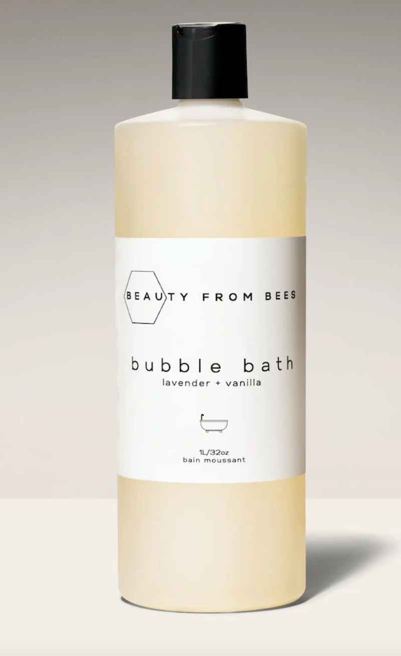 A clear 1L plastic bottle of "Beauty From Bees" lavender vanilla bubble bath with a white label.