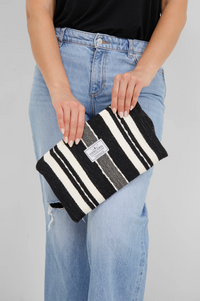 Thumbnail for A close-up of a person holding the small Black/Ecru striped Turkish cotton bag, highlighting the hand-embroidered details and Tofino Towel Co. logo
