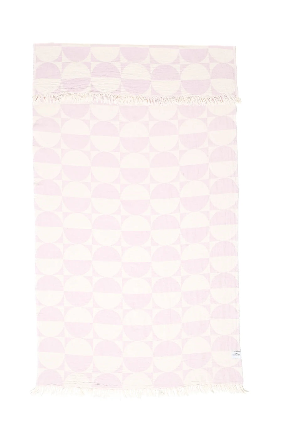 A full-length vertical view of the lilac and cream geometric Phase towel. The top edge is folded over to show the reversible nature of the jacquard pattern, with hand-tied tassels visible on both ends.