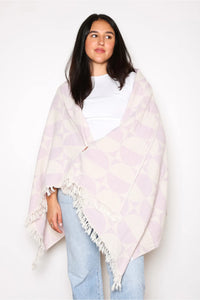 Thumbnail for A woman draped in the lilac Phase towel like a shawl, demonstrating its soft, lightweight texture. The towel covers her shoulders and torso, held against a white t-shirt and light blue jeans.
