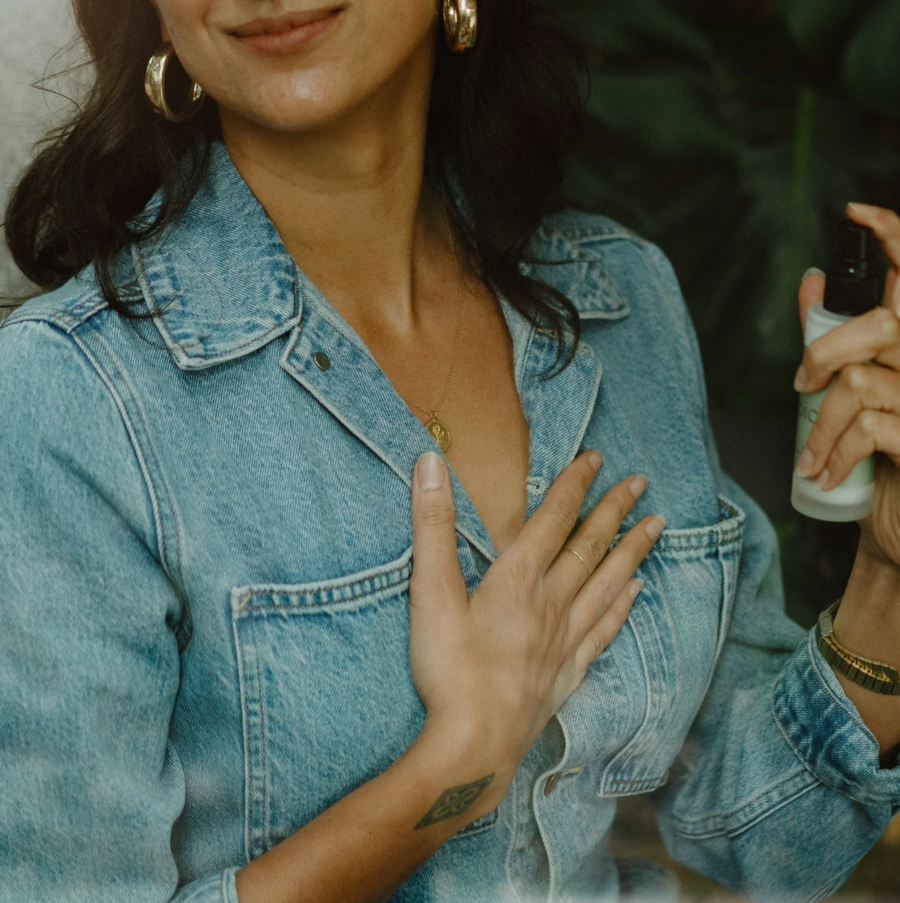 A woman in a denim jacket holds a small "picot refresh" bottle in one hand while placing her other hand on her chest.
