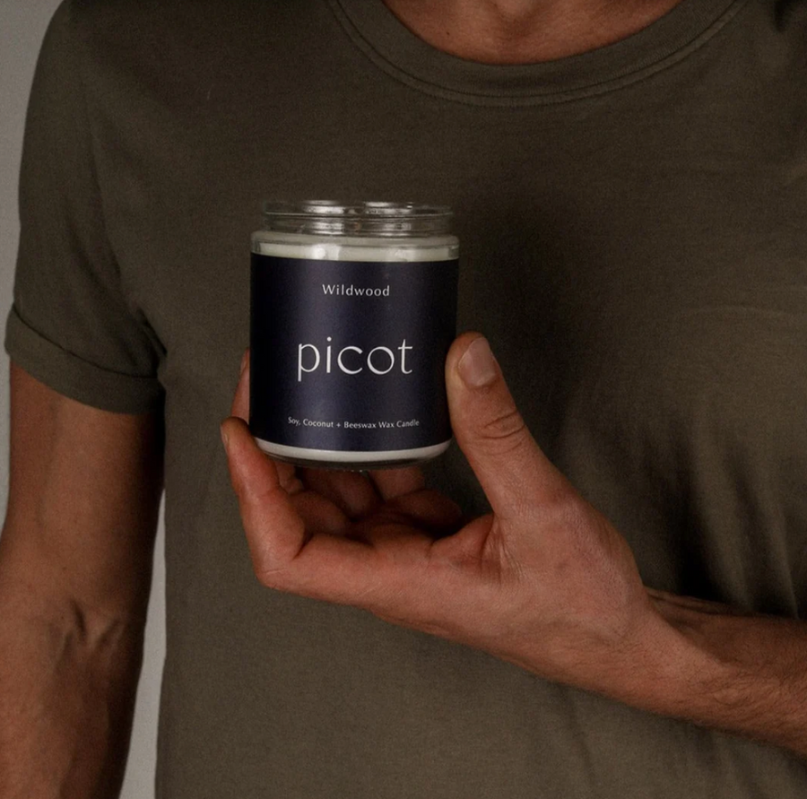 
A hand holds a "Wildwood picot" candle.