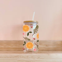 Thumbnail for Clear glass cup with a bamboo lid and glass straw, decorated with a repeating pattern of orange slices, evergreen branches, and small pink flowers.
